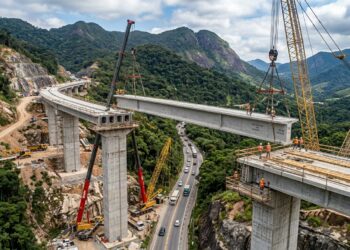 Viga pré-moldada é içada entre pilares de um novo viaduto na Serra das Araras.