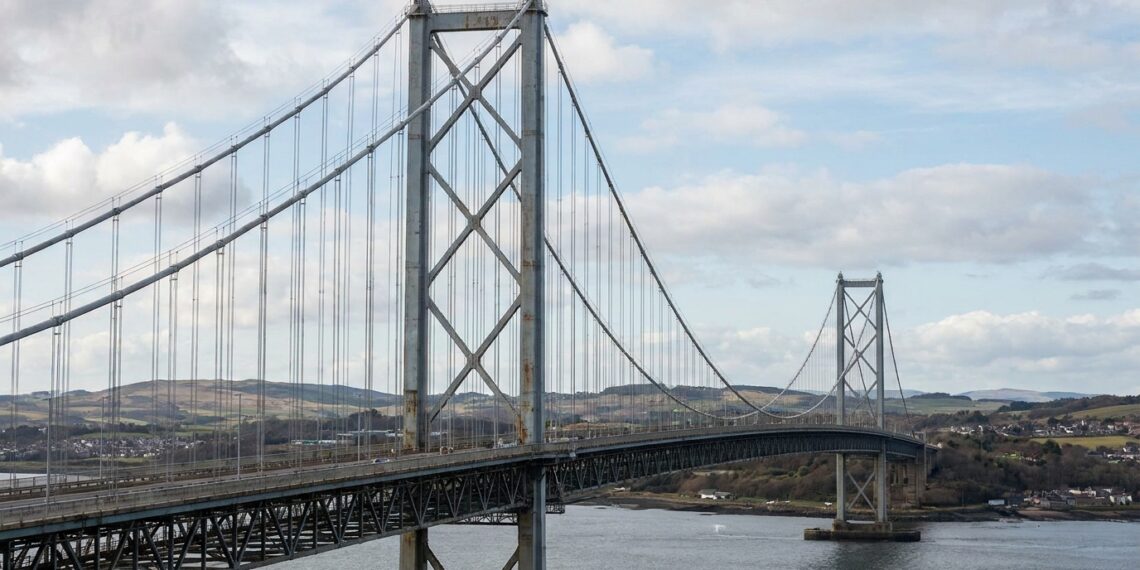 Ponte suspensa Forth Road Bridge, na Escócia, com torres altas e grandes cabos de aço atravessando o estuário.