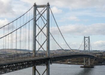 Ponte suspensa Forth Road Bridge, na Escócia, com torres altas e grandes cabos de aço atravessando o estuário.