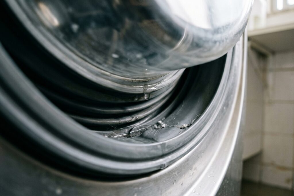 Inspecting_washing_machine_door_%E2%80%A6_24ff86cc-1024x683 Como limpar a máquina de lavar por dentro e reduzir odores e manchas nas roupas