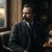 Representação hiper-realista de Friedrich Nietzsche sentado em um escritório do século XIX, com expressão reflexiva e montanhas iluminadas ao fundo.