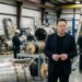 Elon Musk observa um protótipo em ambiente de engenharia aeroespacial.
