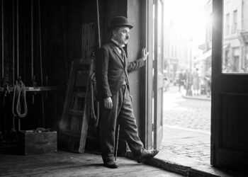 Representação artística de Charles Chaplin diante de uma passagem iluminada, simbolizando a coragem de enfrentar o desconhecido.