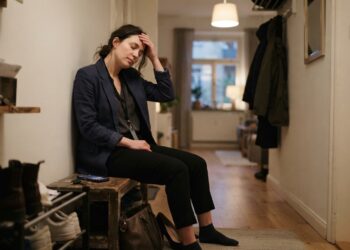 Profissional cansado chega em casa e faz uma pausa silenciosa após um dia de interações sociais.