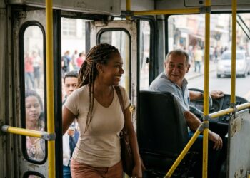 Passageiros entram em um ônibus urbano e cumprimentam o motorista durante a rotina diária.