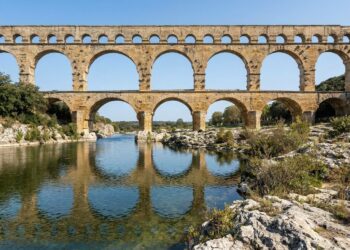 Ponte Pont du Gard, na França, com três níveis de arcos de pedra atravessando o vale do rio Gardon.