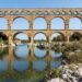 Ponte Pont du Gard, na França, com três níveis de arcos de pedra atravessando o vale do rio Gardon.