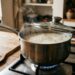Arroz cozinhando em fogo baixo dentro de uma panela parcialmente tampada.