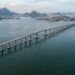 Vista aérea da Ponte Rio–Niterói atravessando a Baía de Guanabara, com seus longos trechos de concreto e o vão central metálico.