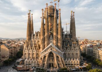 Basílica da Sagrada Família em Barcelona com suas torres centrais e detalhes arquitetônicos de pedra.