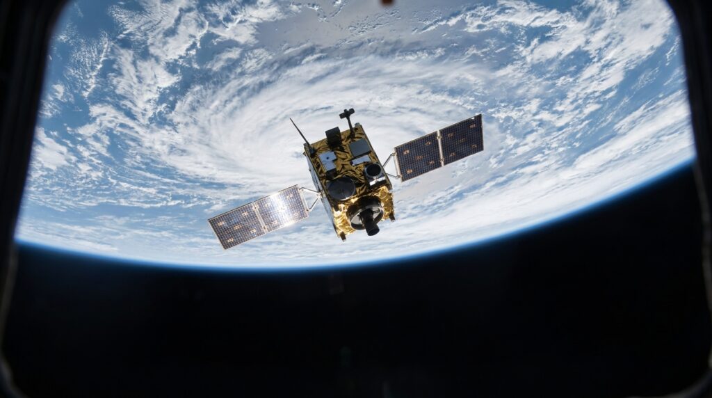 Satélite de observação passando sobre a curvatura da Terra em uma órbita baixa.