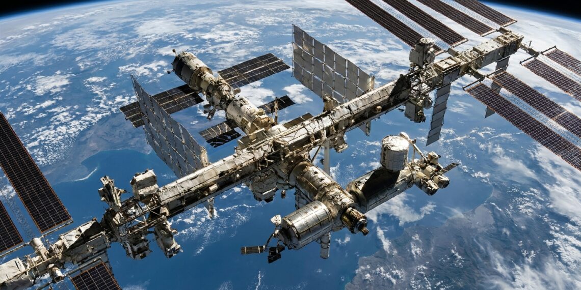 Estação Espacial Internacional com módulos habitáveis e grandes painéis solares sobre a curvatura azul da Terra.