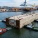 Módulo de concreto do túnel é rebocado flutuando pelo canal de Santos.