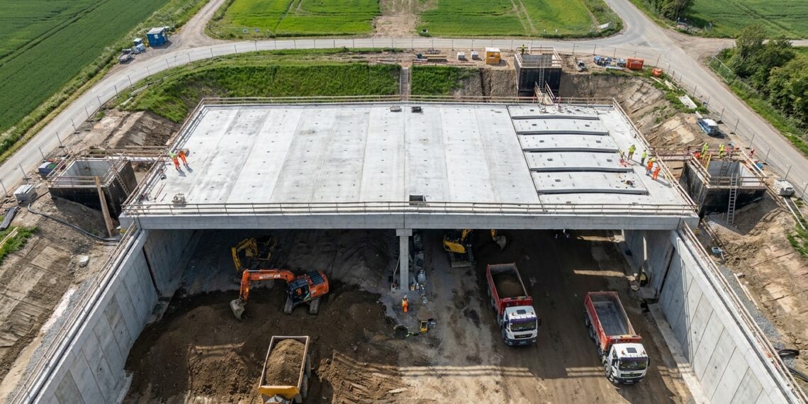 Máquinas escavam sob a cobertura de concreto durante a construção top-down do túnel de Burton Green.