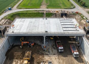 Máquinas escavam sob a cobertura de concreto durante a construção top-down do túnel de Burton Green.