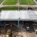 Máquinas escavam sob a cobertura de concreto durante a construção top-down do túnel de Burton Green.