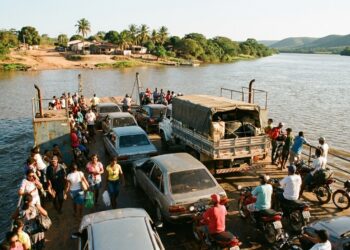 Balsa transportando veículos e passageiros pelo Rio São Francisco em uma travessia entre comunidades ribeirinhas.
