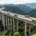 Viaduto de concreto do Rodoanel Norte sobre um vale arborizado na região metropolitana de São Paulo.