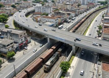Viaduto urbano passa sobre uma ferrovia ativa enquanto carros e trens circulam em níveis separados em Barra Mansa.