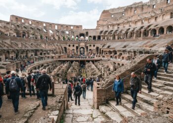 Visitantes observam as arquibancadas e a arena no interior do Coliseu de Roma.