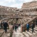 Visitantes observam as arquibancadas e a arena no interior do Coliseu de Roma.